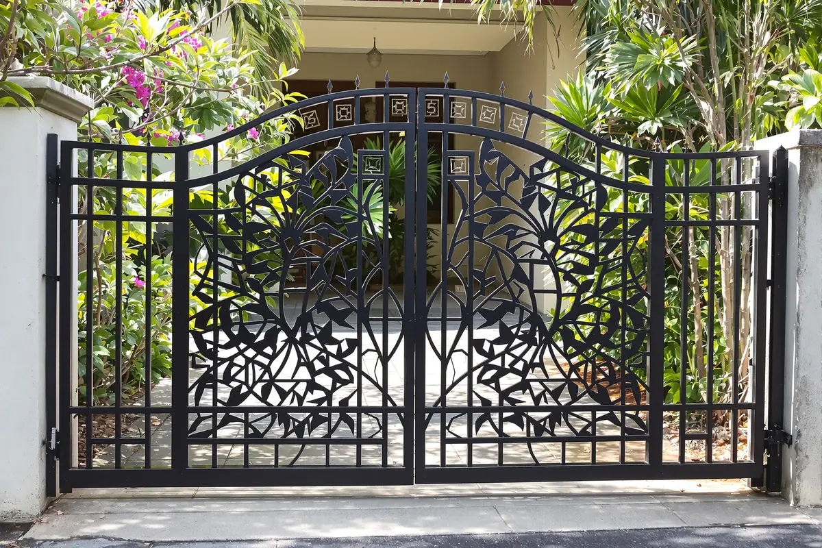 Black double gate with decorative cut-out leaf pattern panels