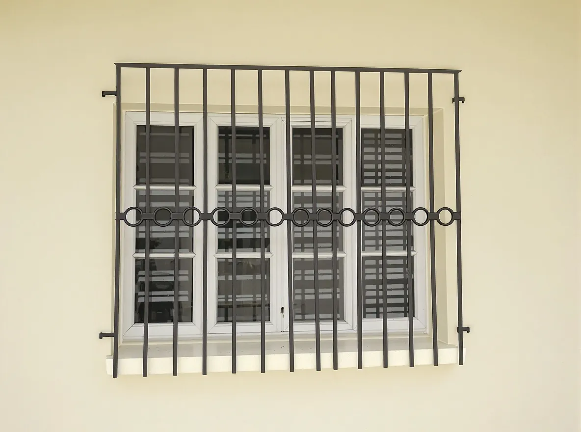 Window grill of vertical bars with a row of steel rings across the middle